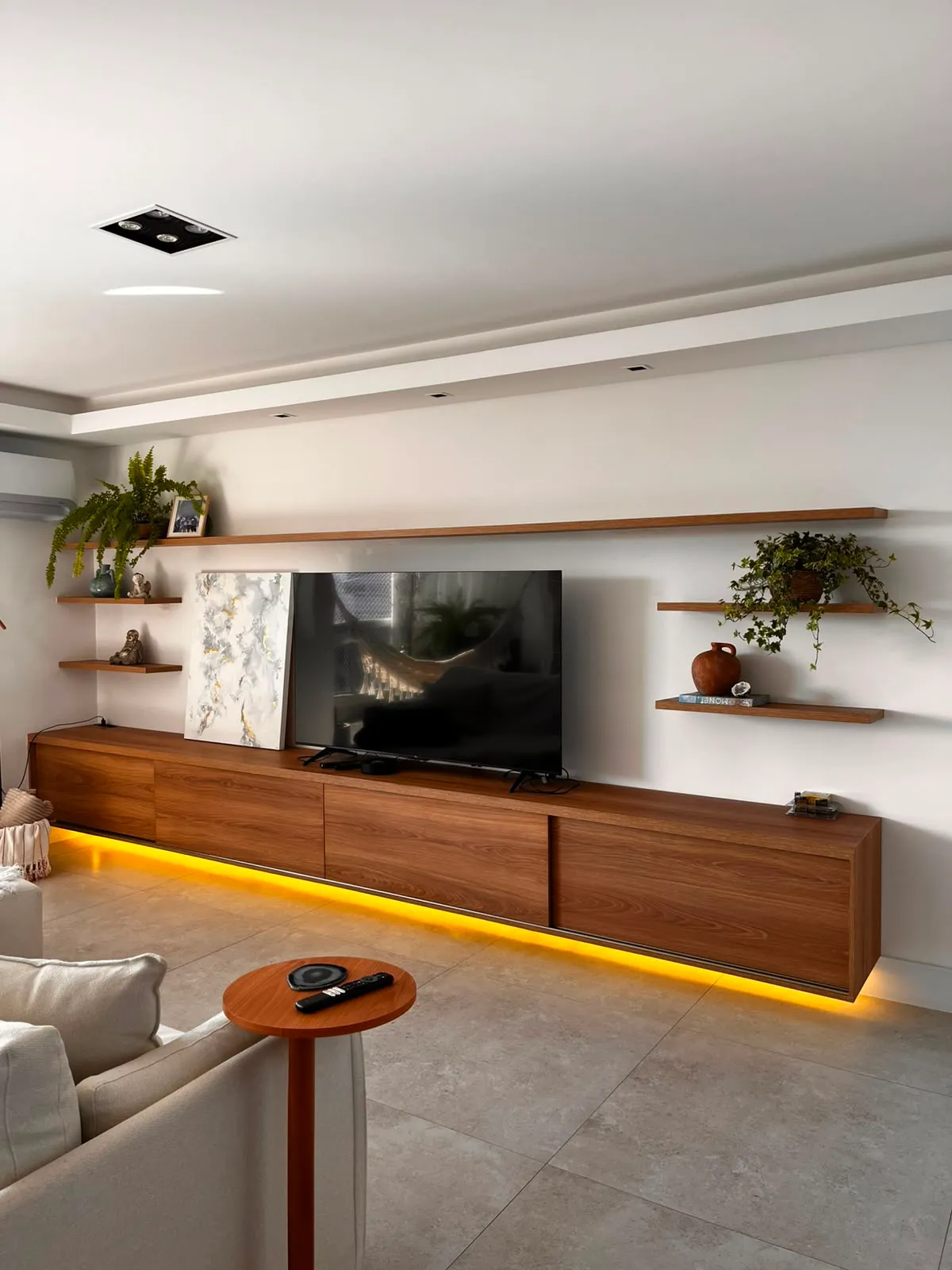 Sala com painel, rack e prateleiras em MDF feitos sob medida pela Kazanova em Joinville